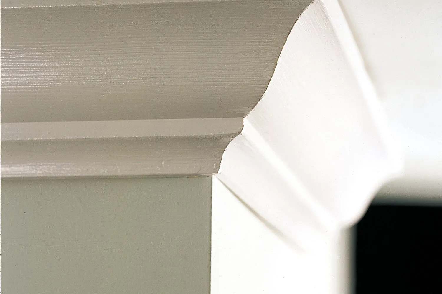 A zoomed in picture of crown molding affixed to the wall of a home.