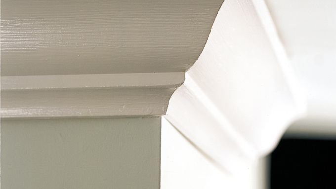 A zoomed in picture of crown molding affixed to the wall of a home.