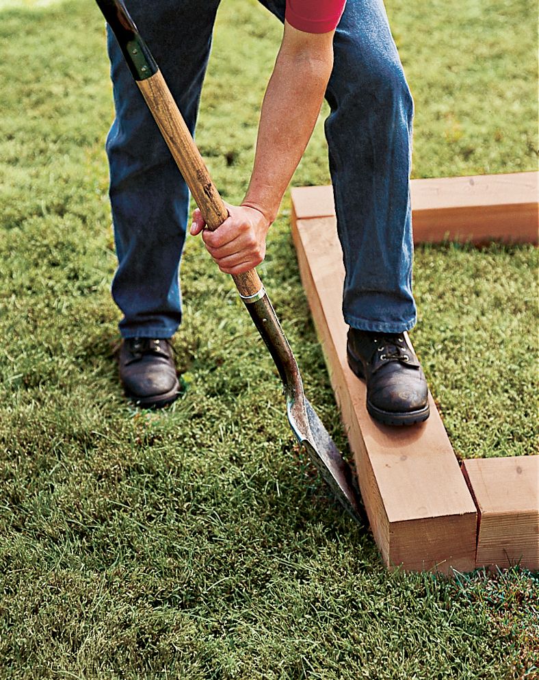 A man marks the outline of a raised planting bed.