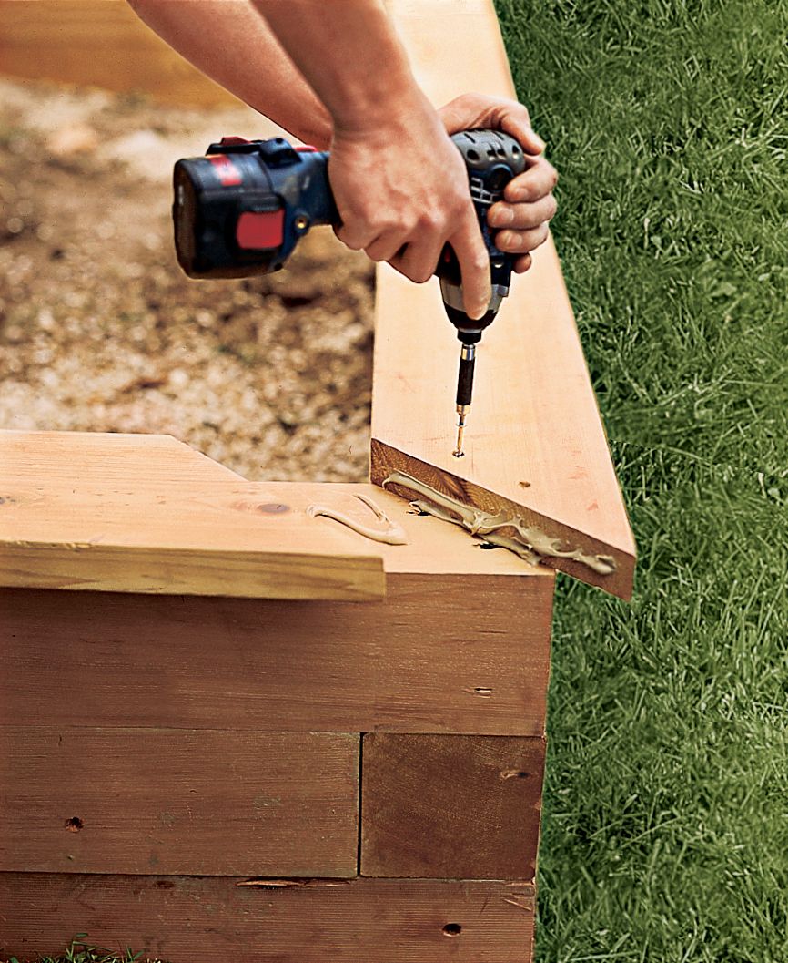 A man installs the cap railing.