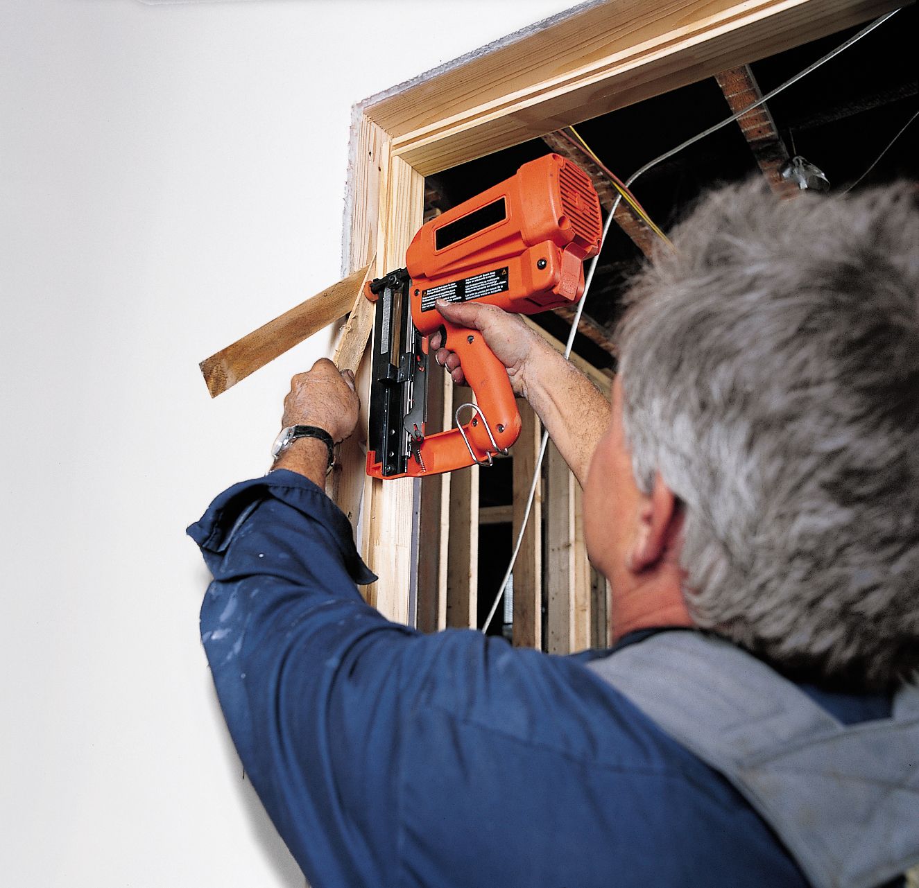 Photo of Tom Silva anchoring the door jam of a prehung door. 