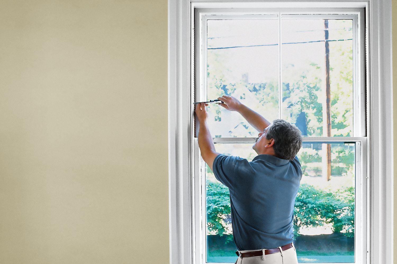 A main working on the side of a window with sashes.