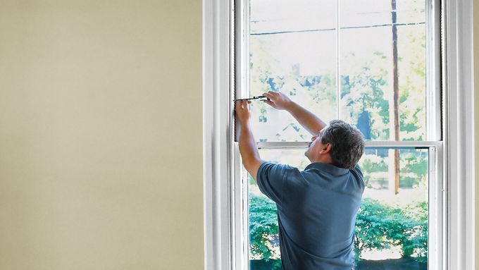 A main working on the side of a window with sashes.