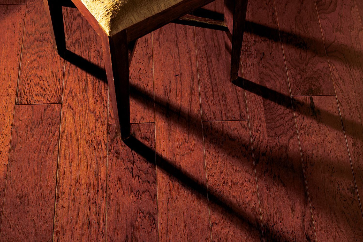 a finished floating wood floor with a chair