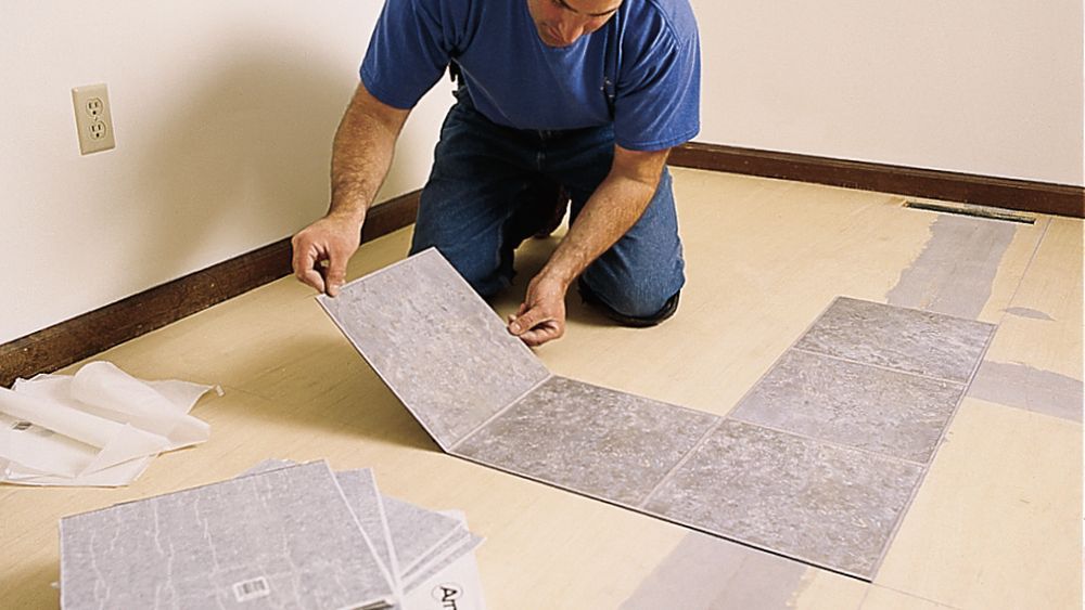 Installing vinyl tile flooring.