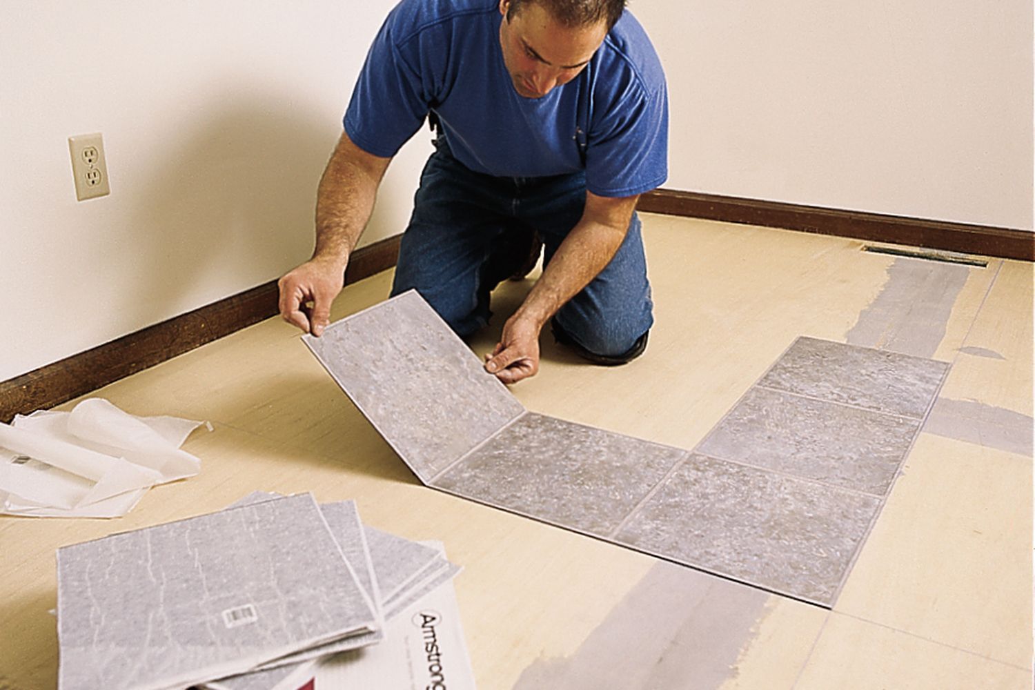 Installing vinyl tile flooring.