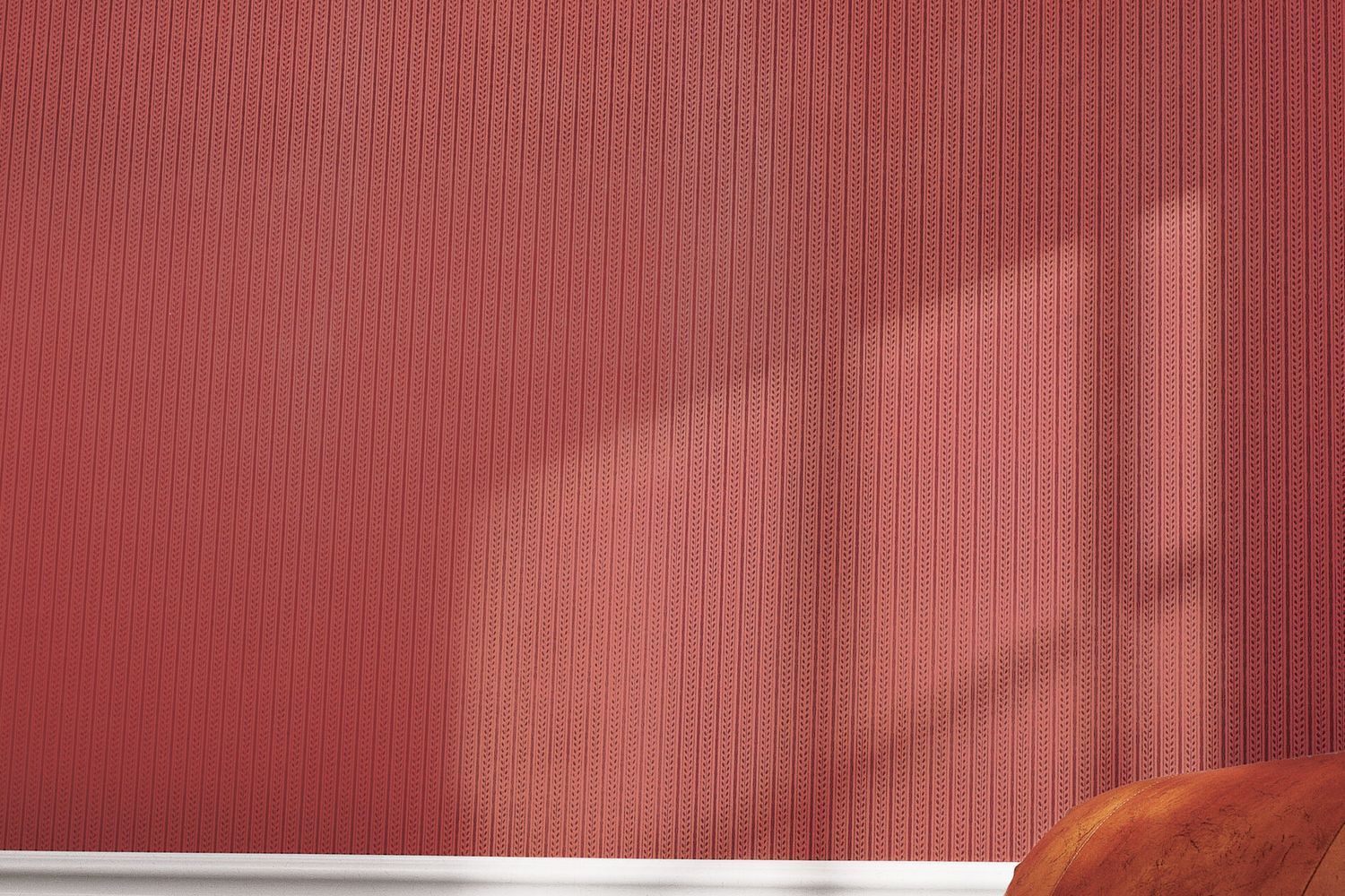 Red patterned wallpaper hanging on the wall of a room.
