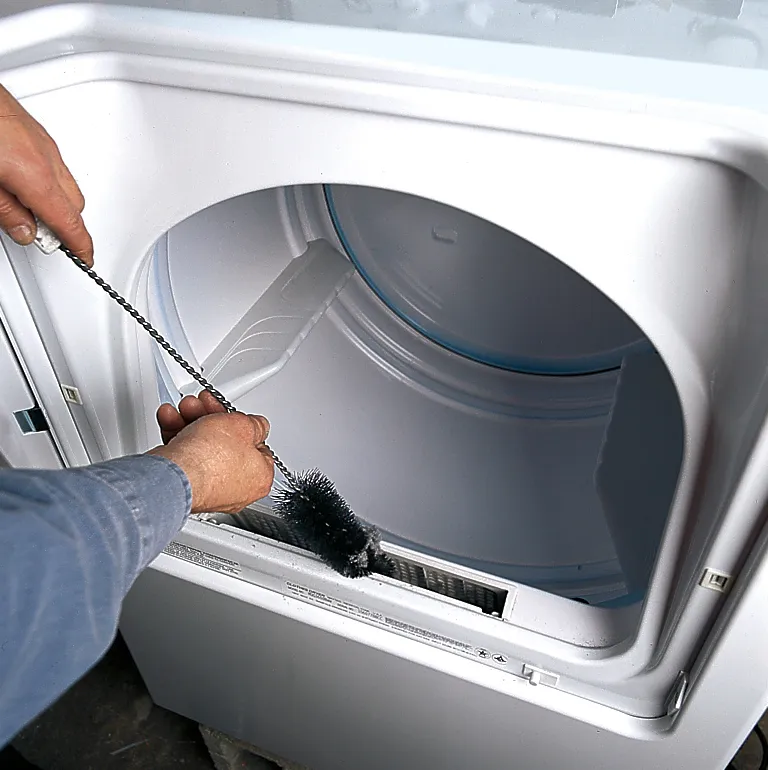 Person cleaning and inspecting the lint trap of the dryer.