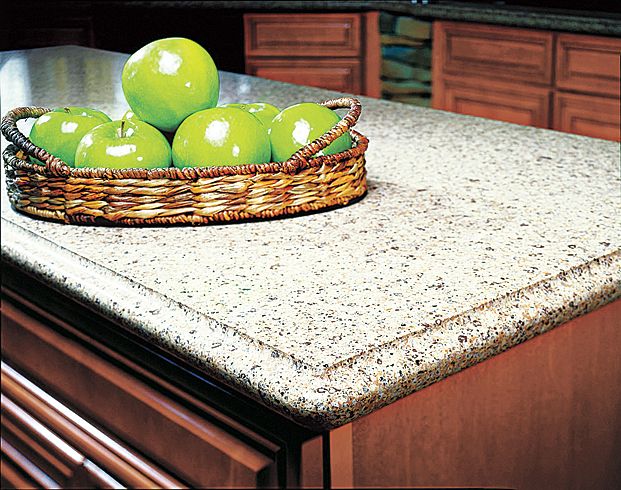 A stone top kitchen island with apples on top.