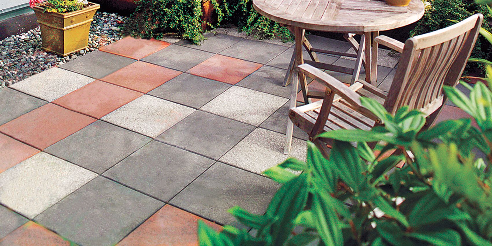 A concrete patio with multicolored tiles.