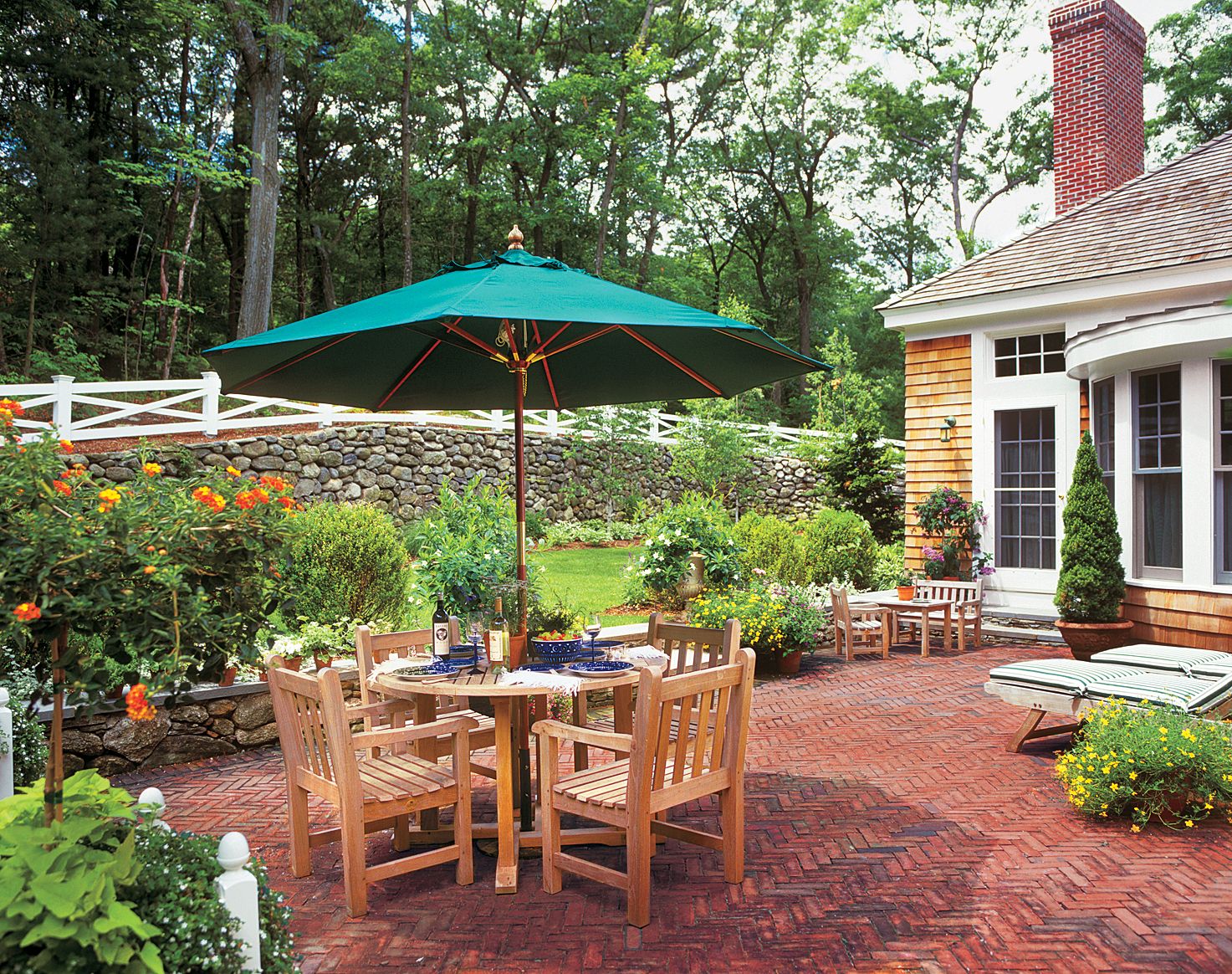 A wooden table on top of a brick pattern patio.