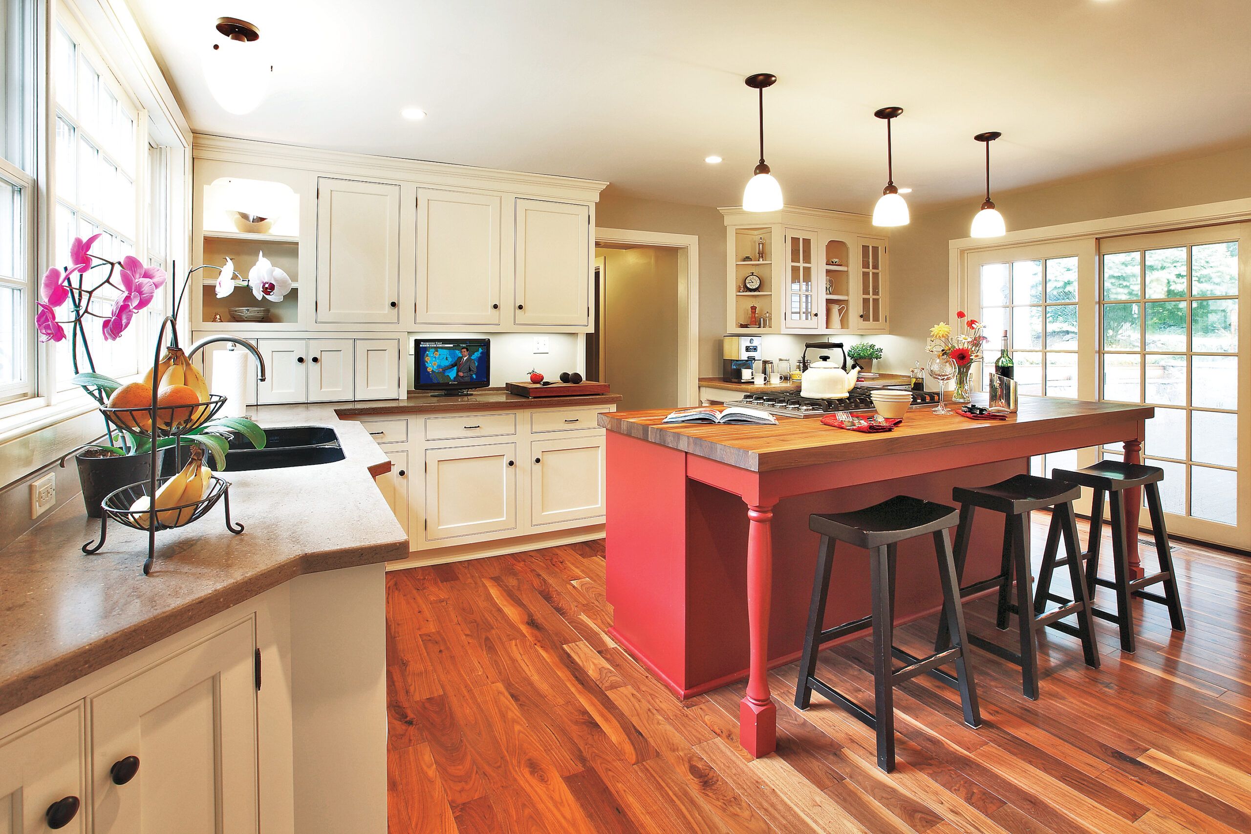 A red kitchen island with stools.