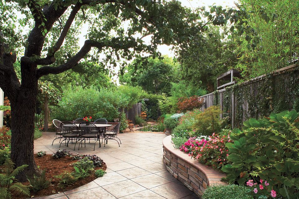 A stone patio with trees hanging over it.