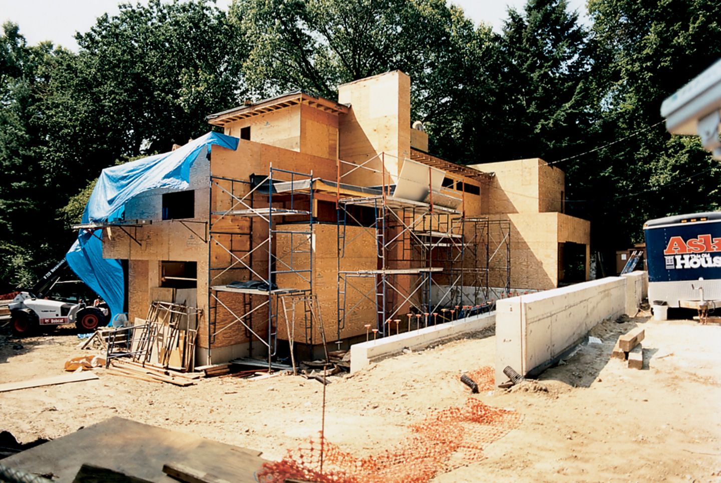 A house with a flat roof in the process of being constructed.