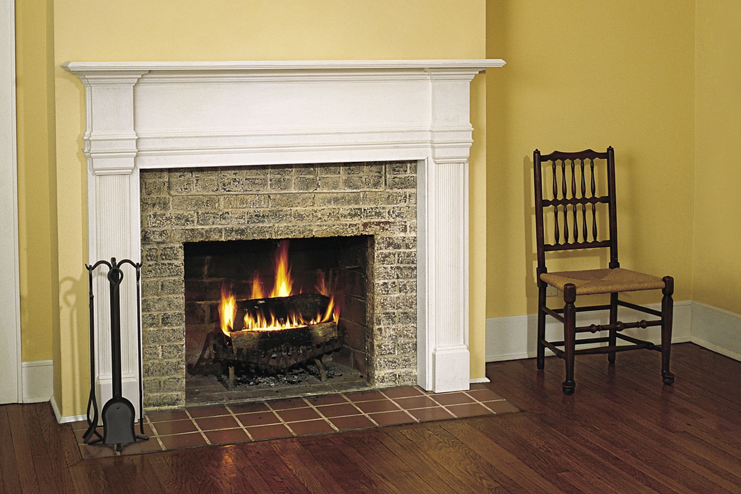 A fireplace mantel ina home beside a chair.