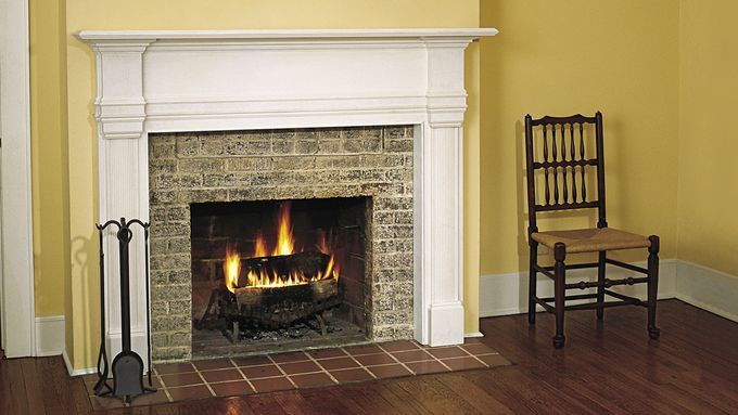 A fireplace mantel ina home beside a chair.