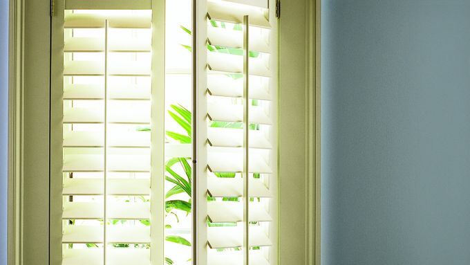 Interior shutters hanging in a window.