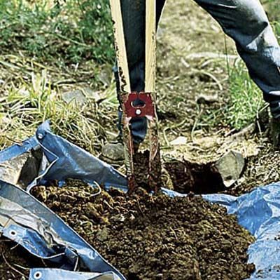 A person digging a posthole for a lamppost.