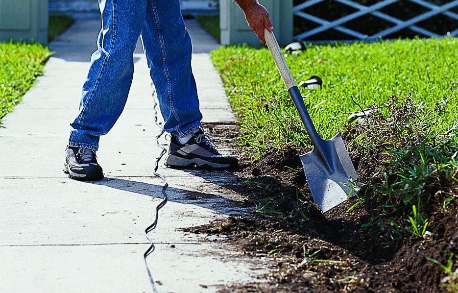 Sod is turned over for landscaping light cables.