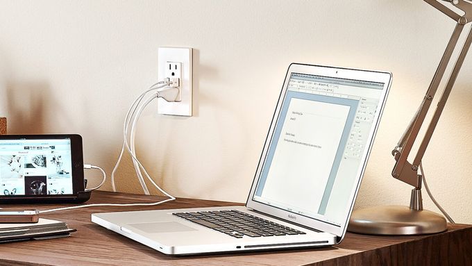 An outlet with a USB charging port near a desk.