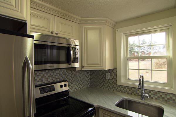 Crown molding is added to upper cabinets to add a creative element to the  budget-friendly makeover kitchen.