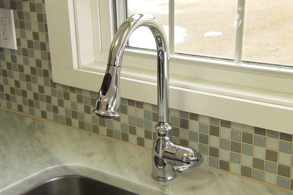 A brand new faucet is added for the budget-friendly kitchen makeover.