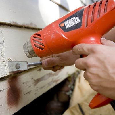 scraping paint from an exterior of a home