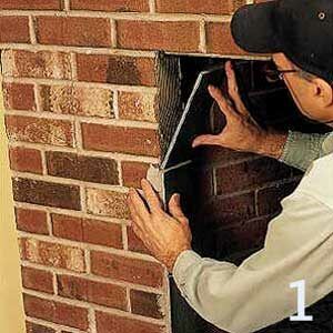 A man covering the brick ends of a fireplace.