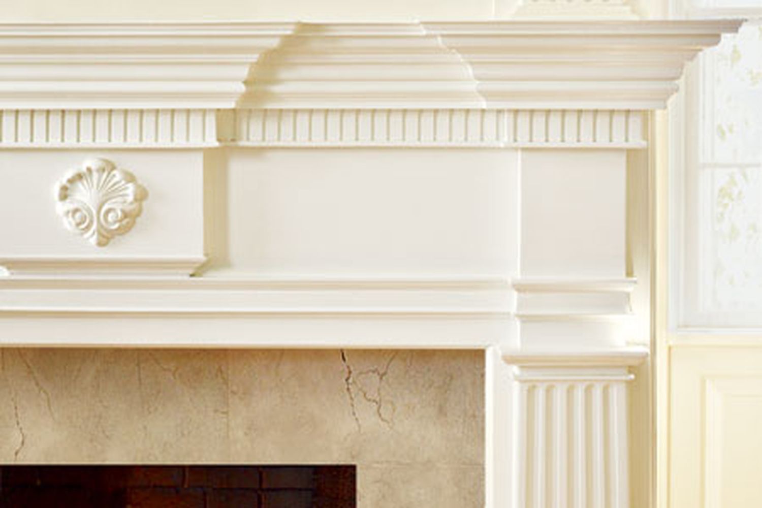 A mantel made with molding profiles above a fireplace.