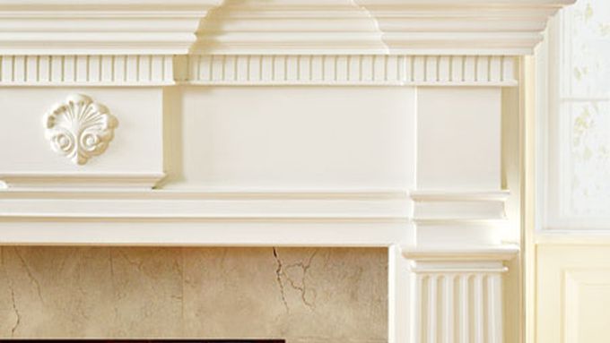 A mantel made with molding profiles above a fireplace.