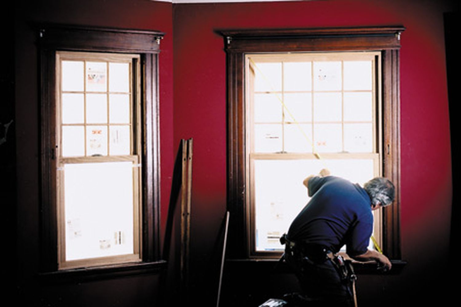 A man measuring angles for a window sill.