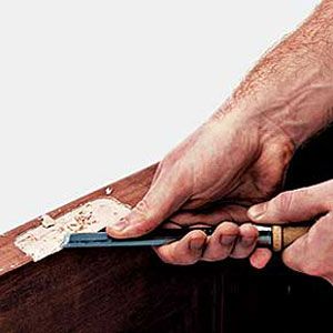 using a chisel to trim the waste of the new mortise