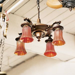 A vintage brass arm light fixture hanging over a room.