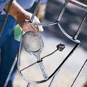 An image of a man spraying his ornamental metalwork.