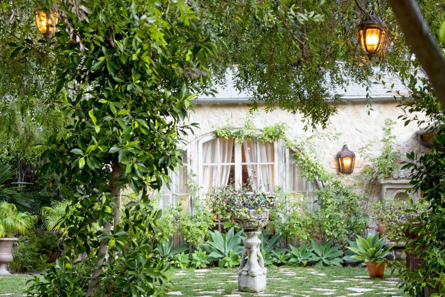 A beautiful backyard in the summer illuminated by lights.