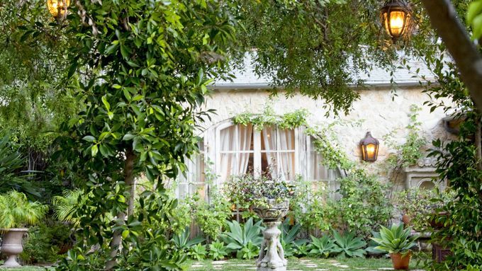 A beautiful backyard in the summer illuminated by lights.