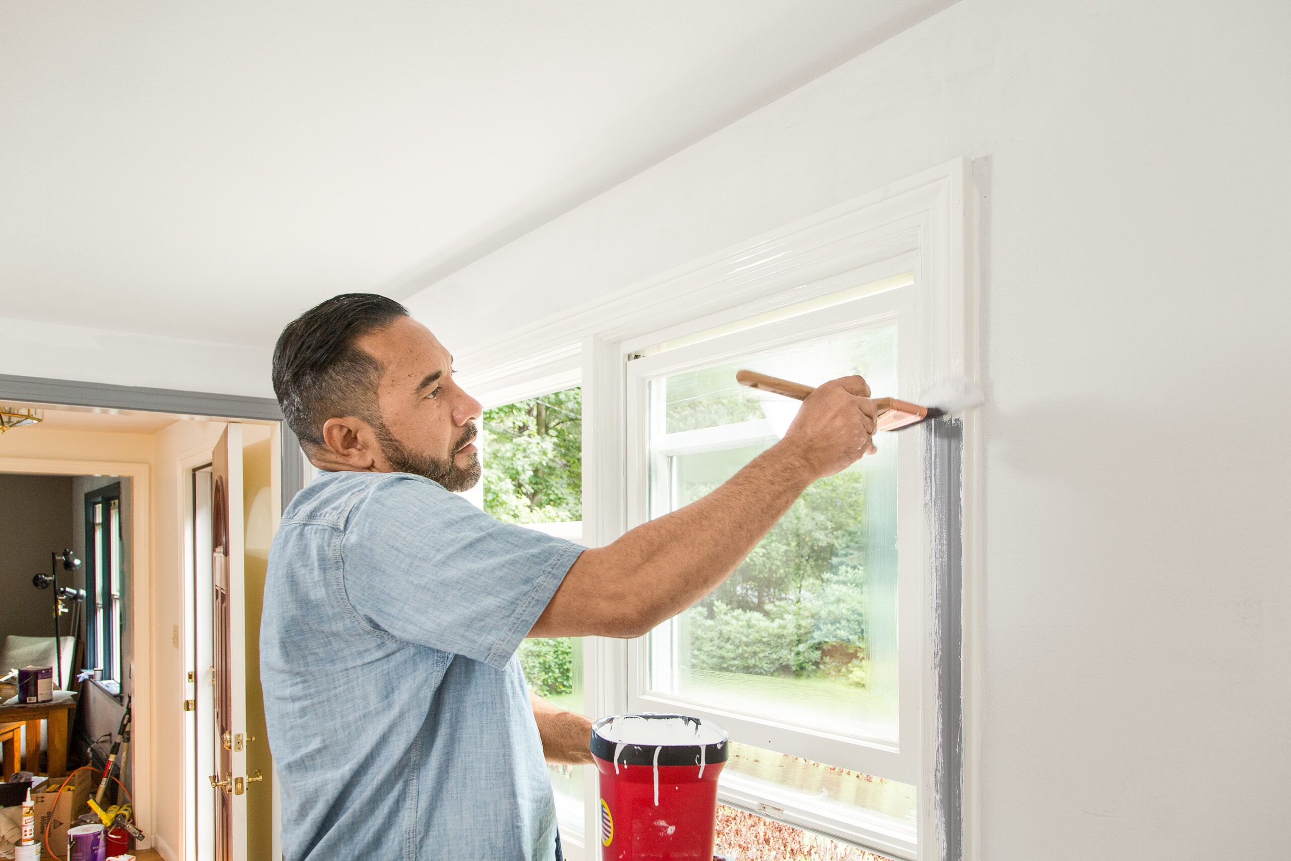 a man painting a wall  and window