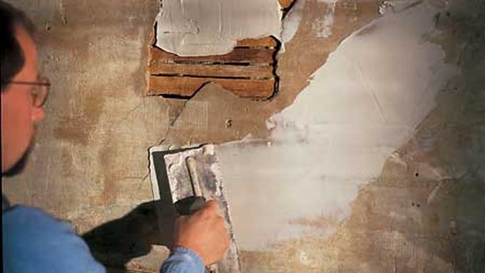 A man applying plaster to a wall.