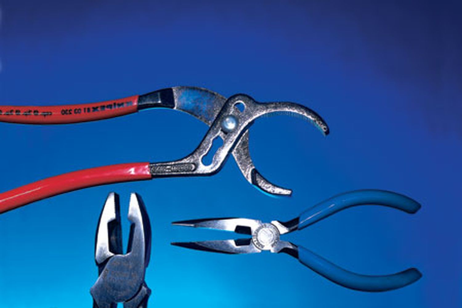 A set of three pliers on a blue background