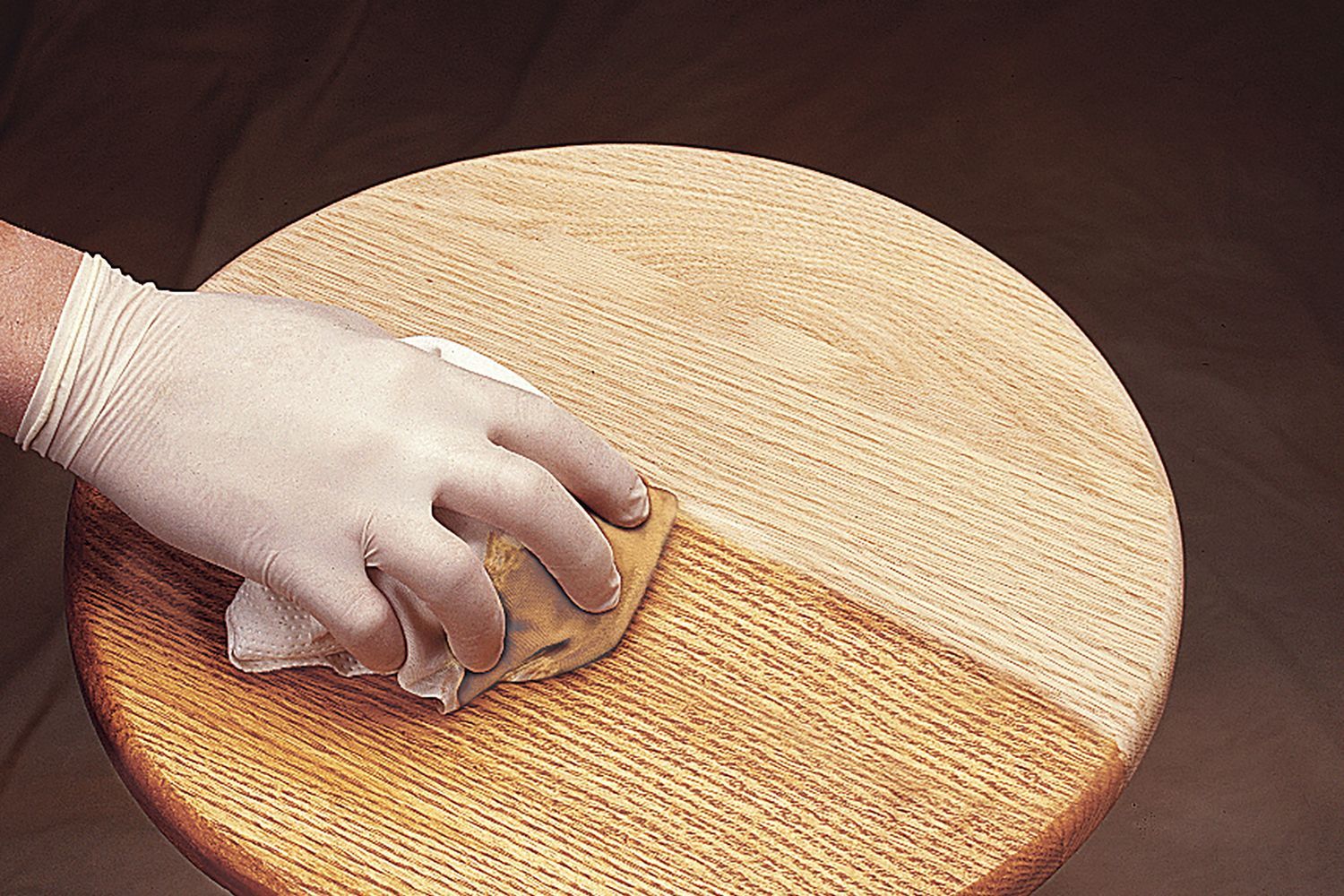 A stool that is having polyurethane applied to its surface.