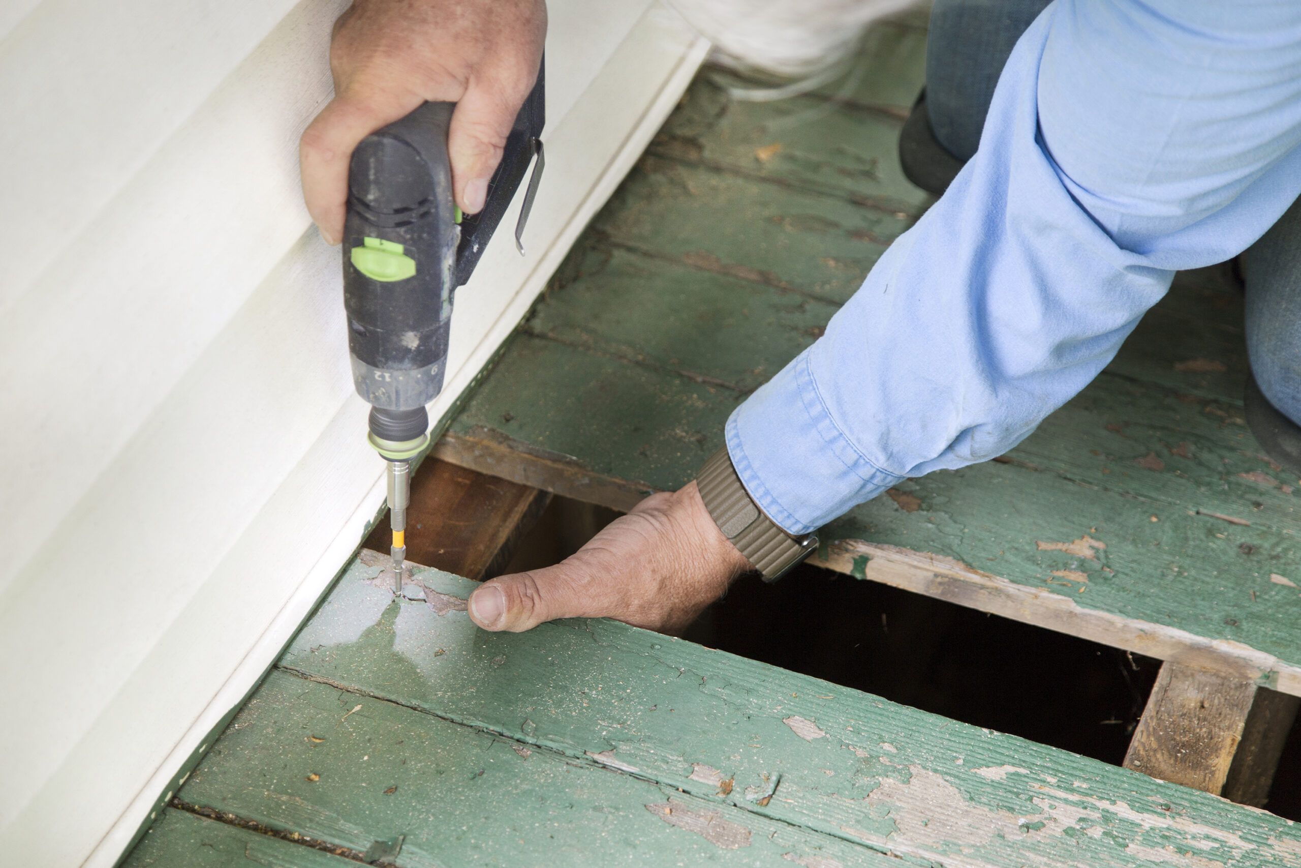 drilling pilot holes into the boards on a porch