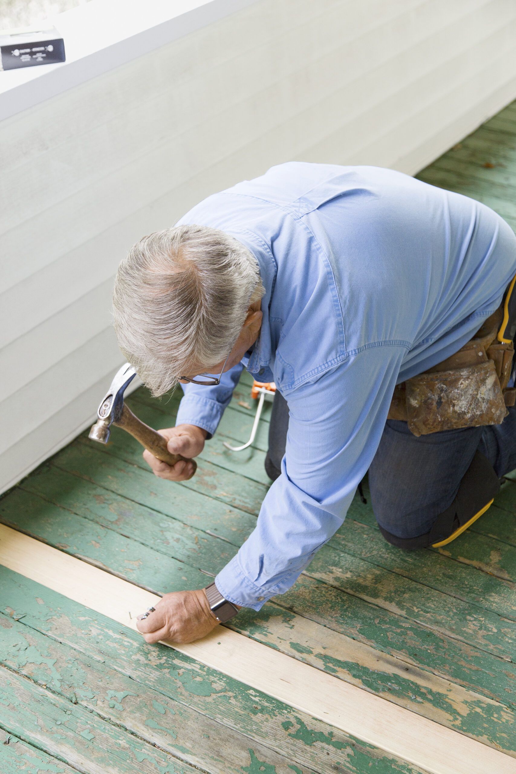 hammering in the new board for a porch