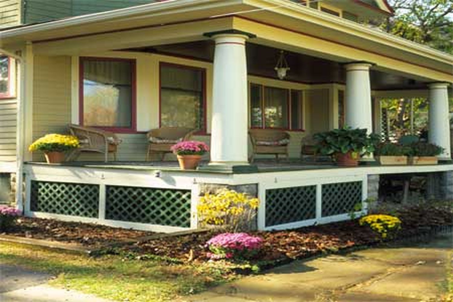 A home with a porch with a wooden lattice beneath it.