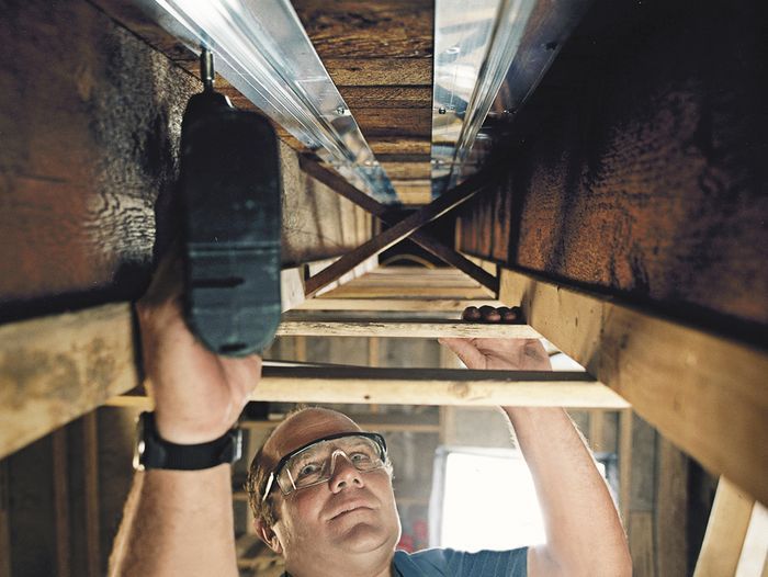 As a part of a home heating system, Richard Trethewey install radiant tubing in a house.