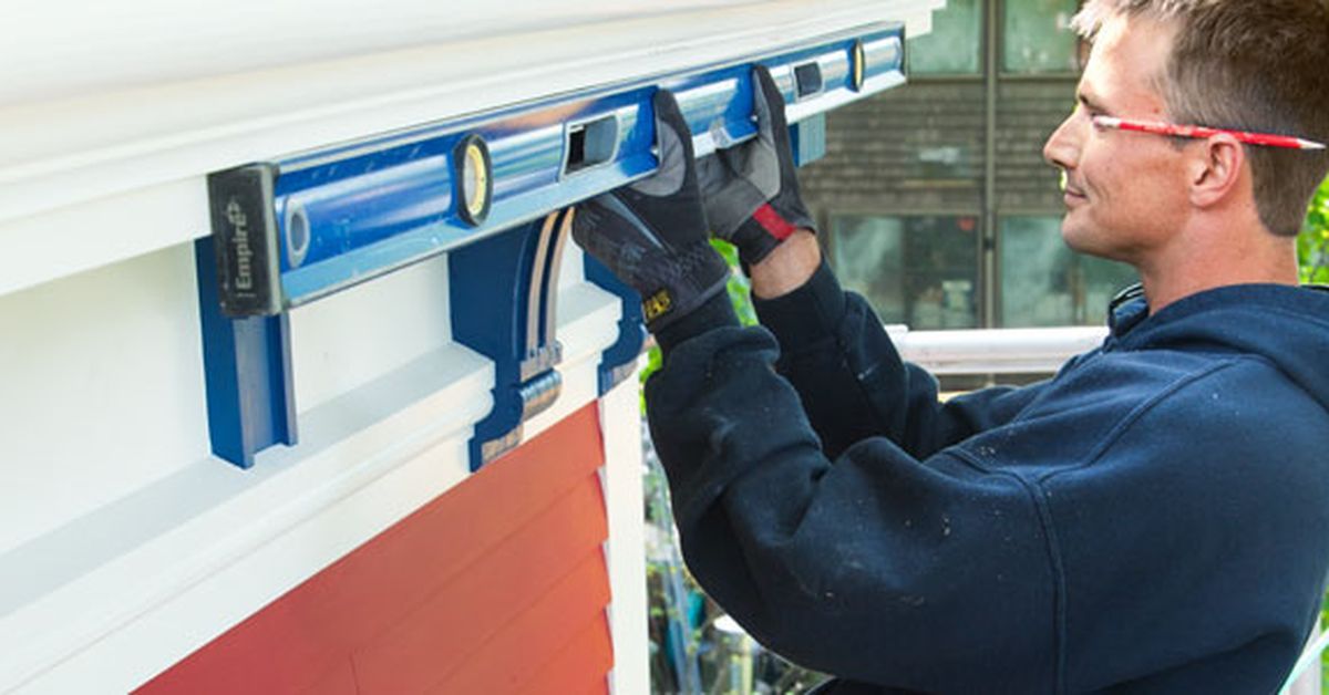 A man installing fiberglass gutters on a roof.