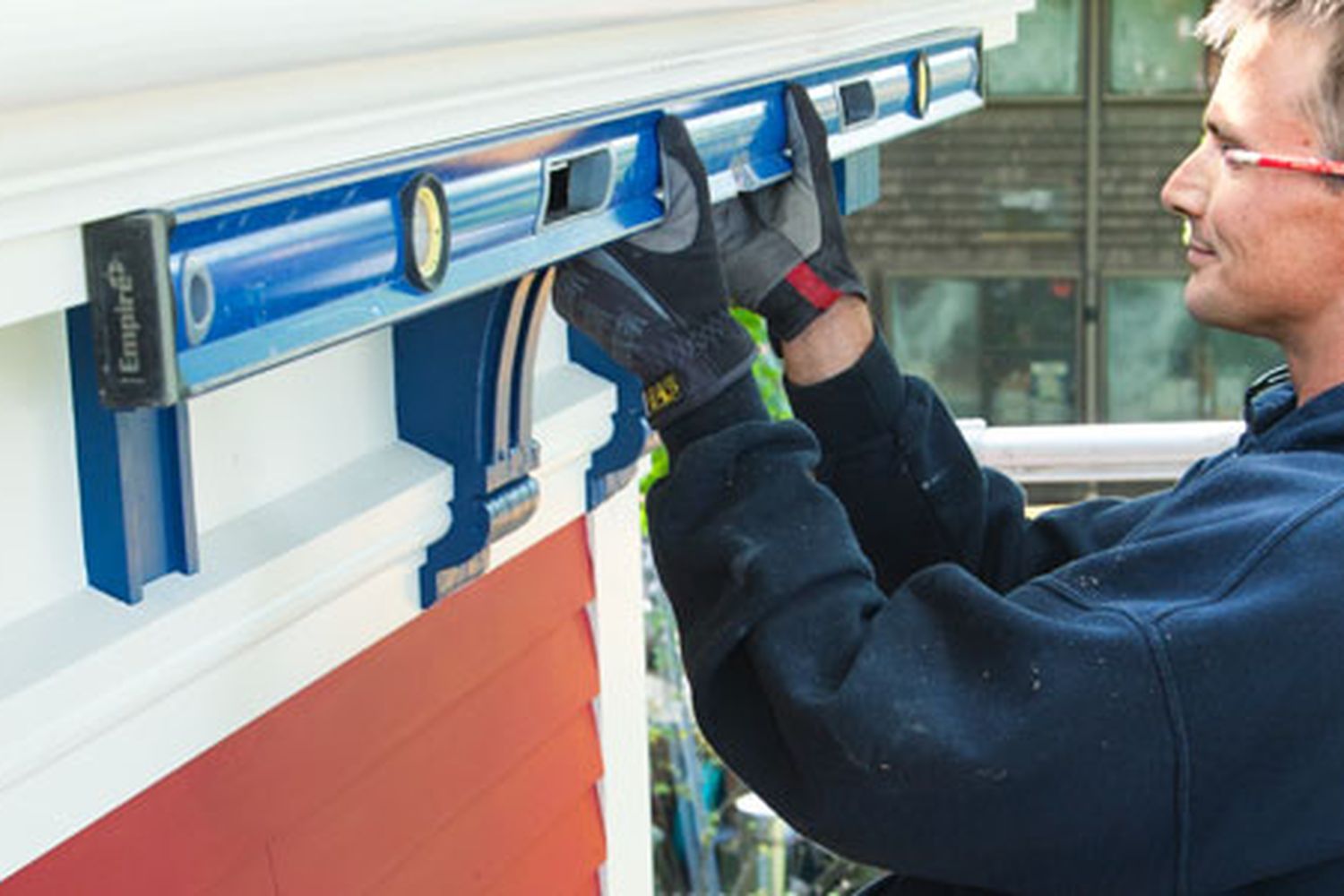 A man installing fiberglass gutters on a roof.