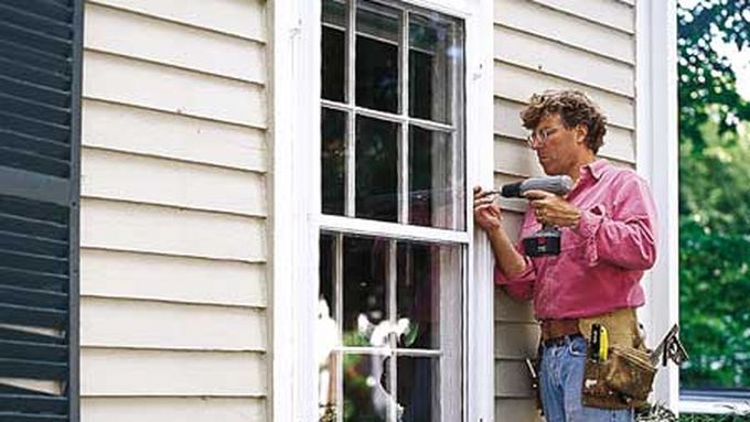 A man replaces window sashes.