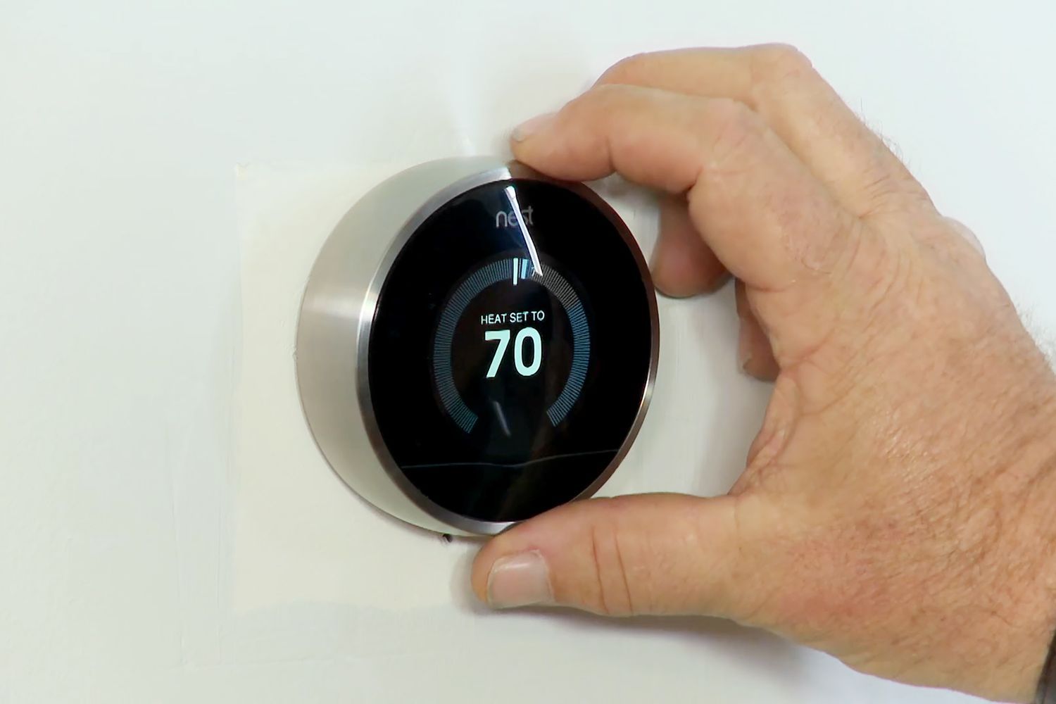 a user adjusting a smart thermostat