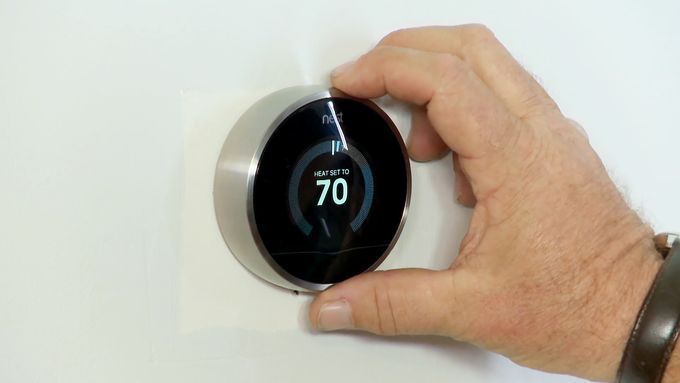 a user adjusting a smart thermostat