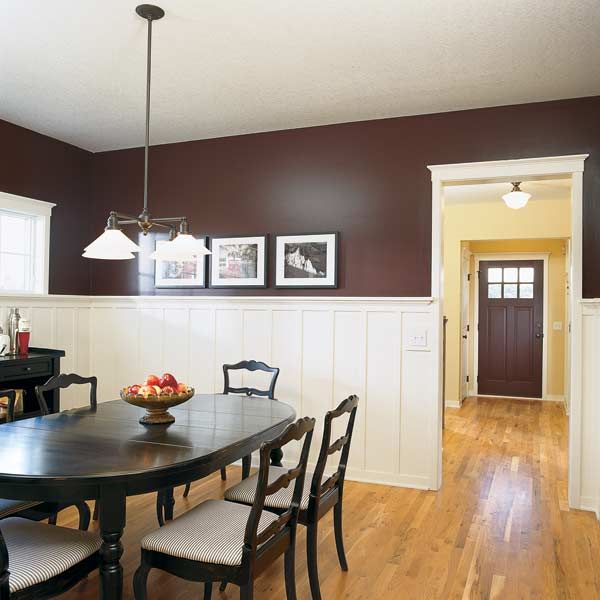 Dining room painted a reddish brown color to make the white wainscoting stand out and tie in a door that's the same color.